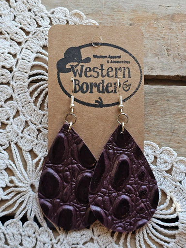 Dark brown leather earrings on a 'Western Border' branded card with lace background